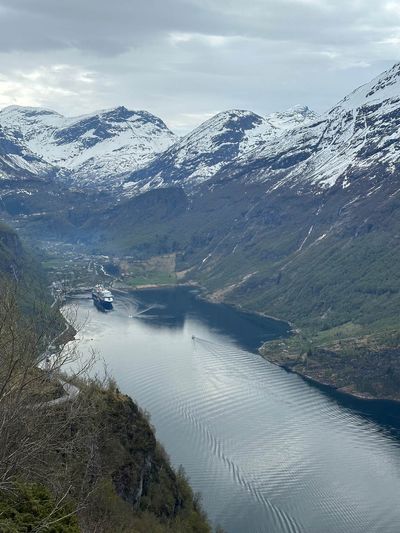 A cruise ship at anchor in Norway’s Geirangerfjord, ringed by snow-capped peaks