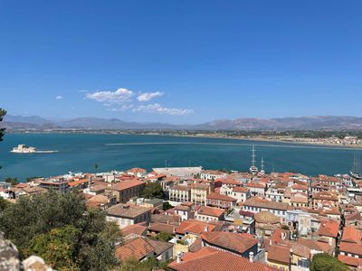 Terracotta rooftops of Nafplio above its calm Greek harbour