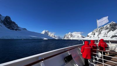 Passengers on a Silversea expedition ship deck taking in Antarctica’s snow-capped mountains